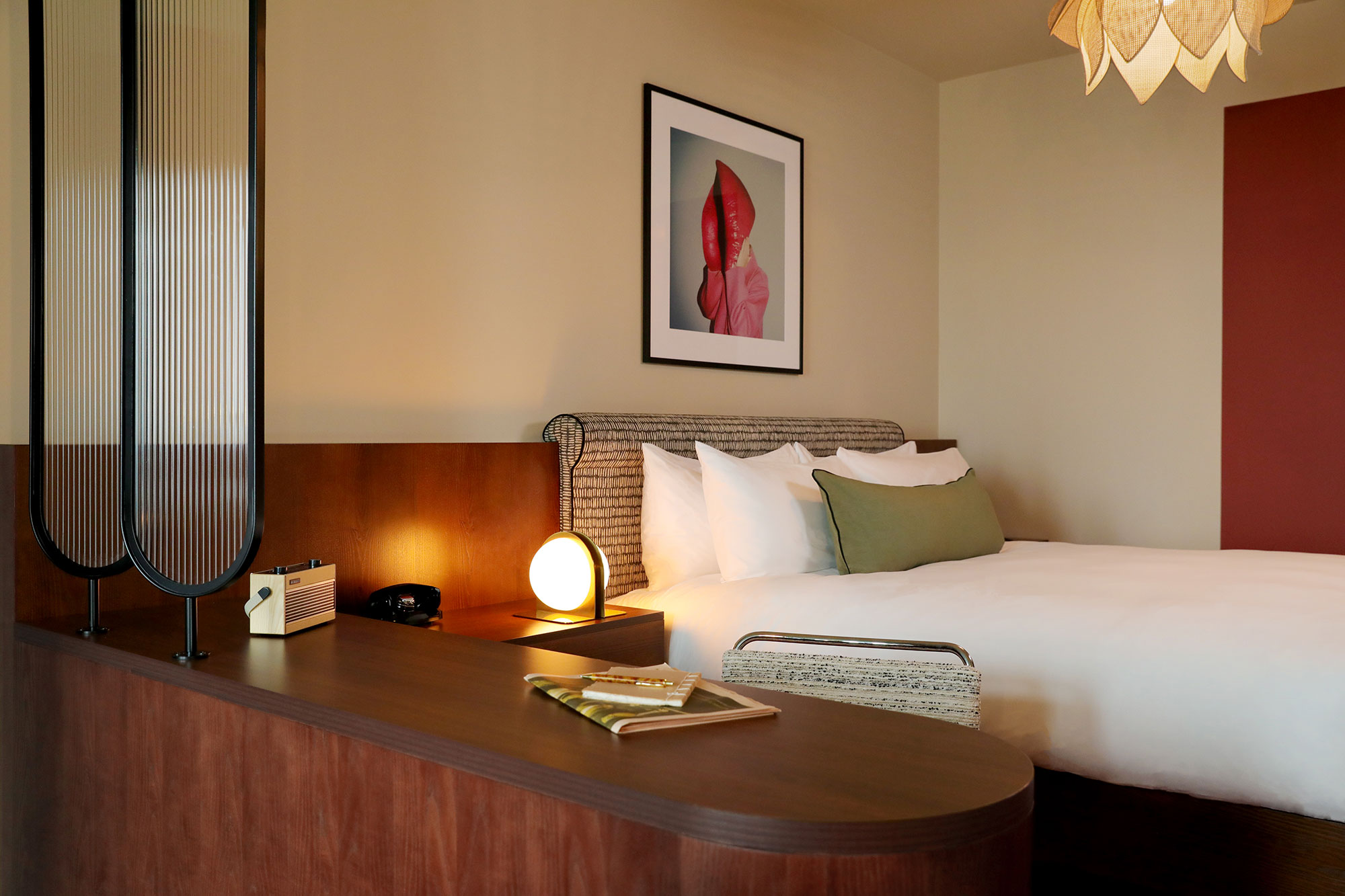 Lamp illuminates the bedspread in the Biggy room, with wooden counter in the foreground.