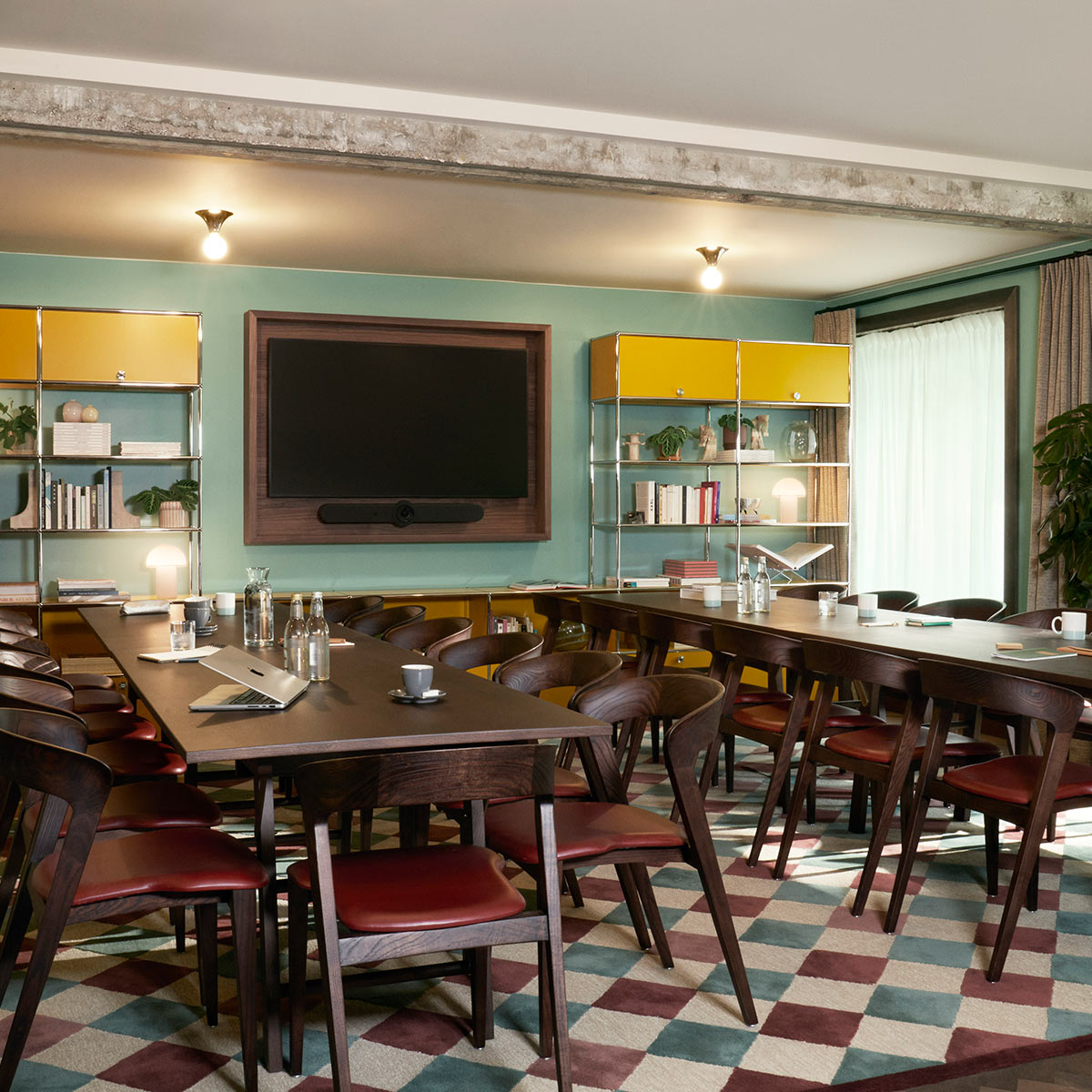 Wood-panelled space for meetings and events in Brussels, with wall-mounted monitor.