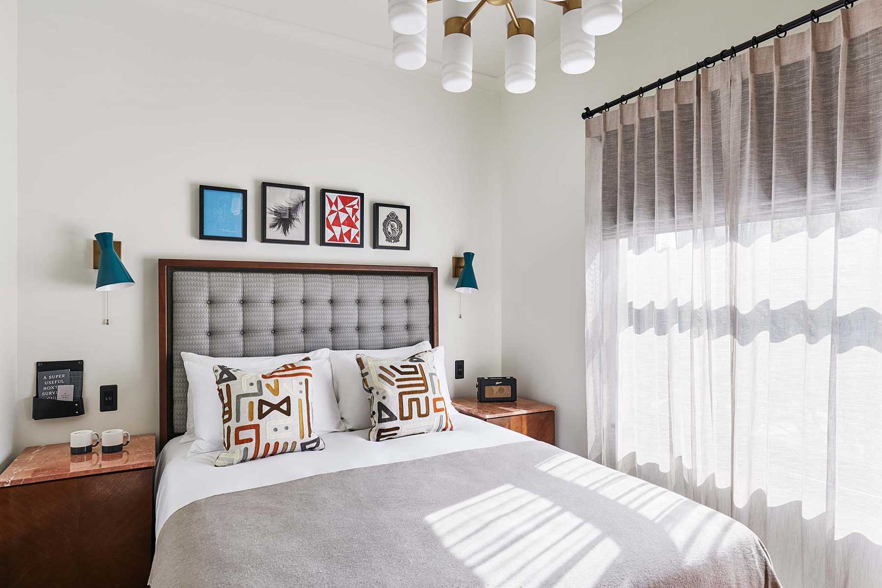 Double bed with bedside tables either side and modern artwork above the headboard