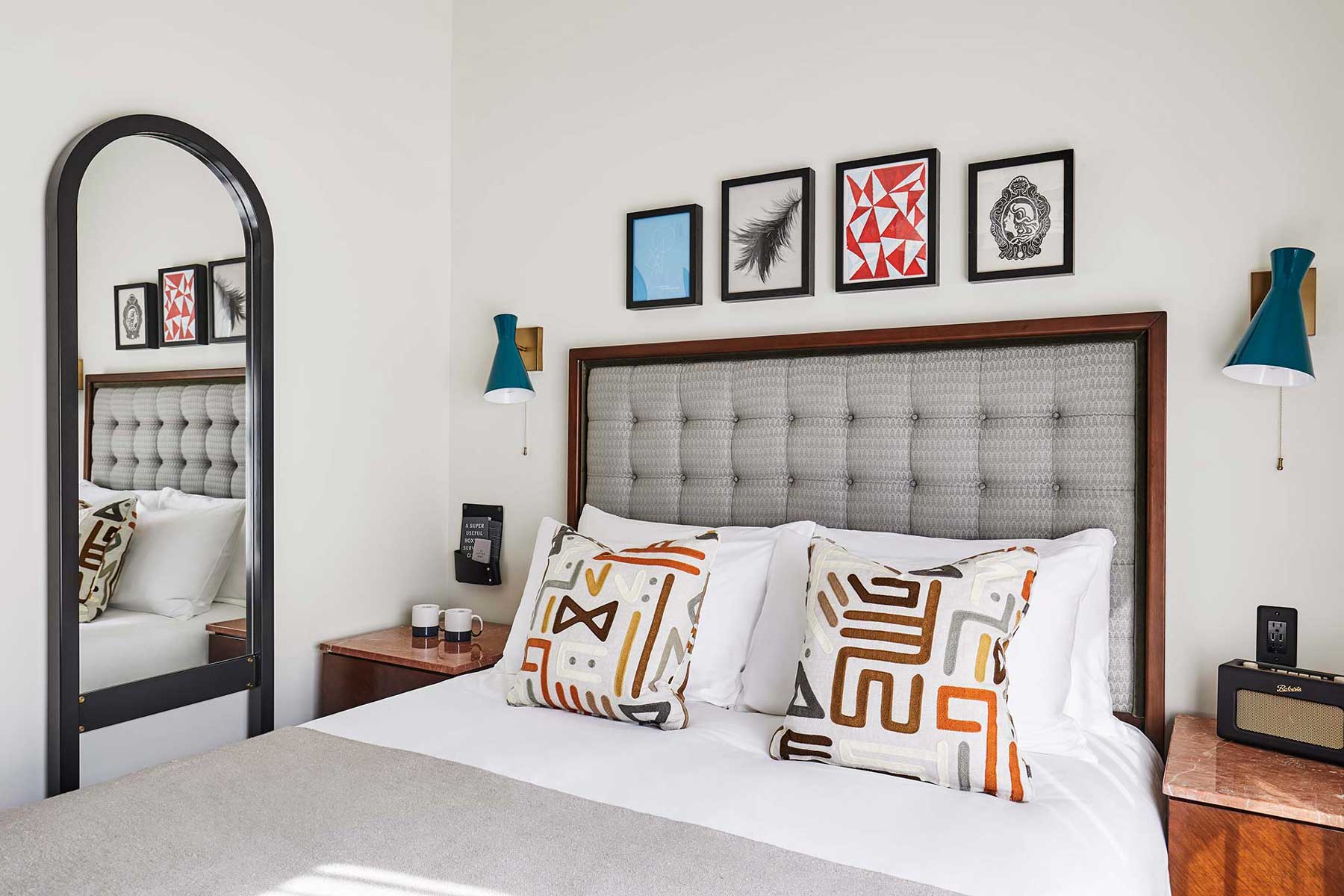 A large mirror is on the wall beside the bed